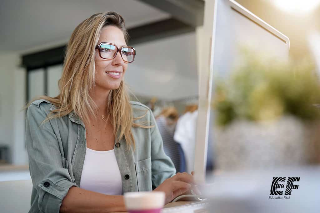 woman smiling while using computer 