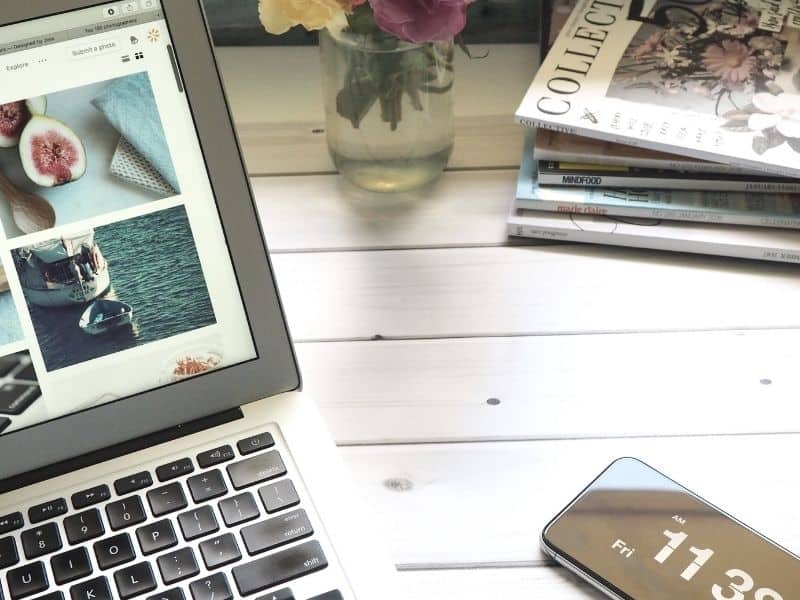 a laptop on a desk with magazines in the background