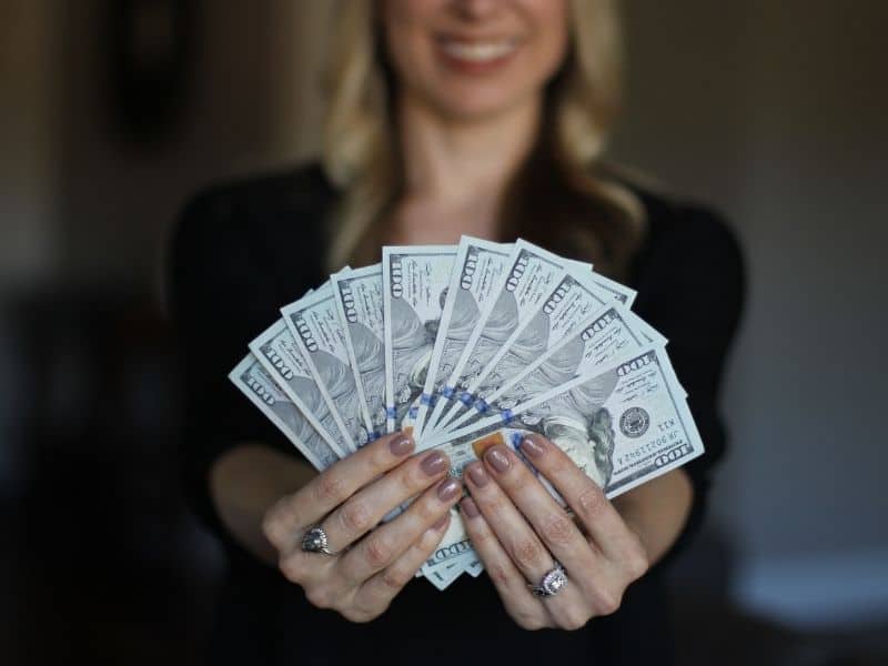 a woman holding money and fanning it out