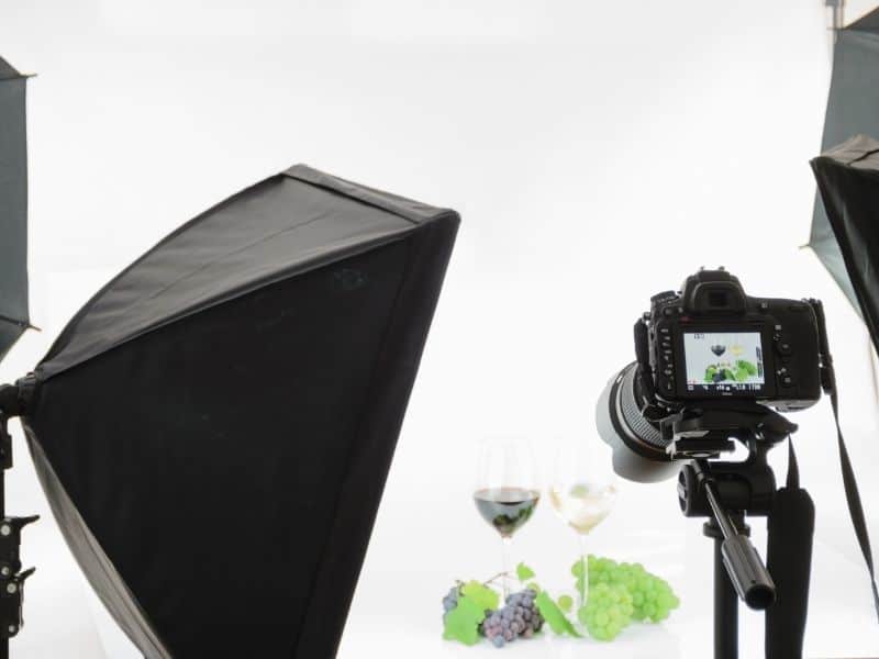 camera on a tripod facing towards 2 wine glasses