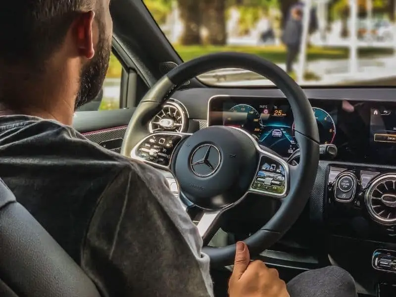 man sitting behind the wheel of a car