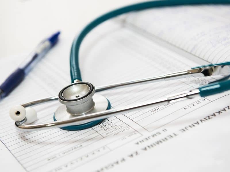 a blue stethoscope sitting on top of papers