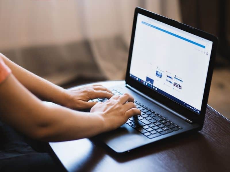 a person typing on a laptop on a table