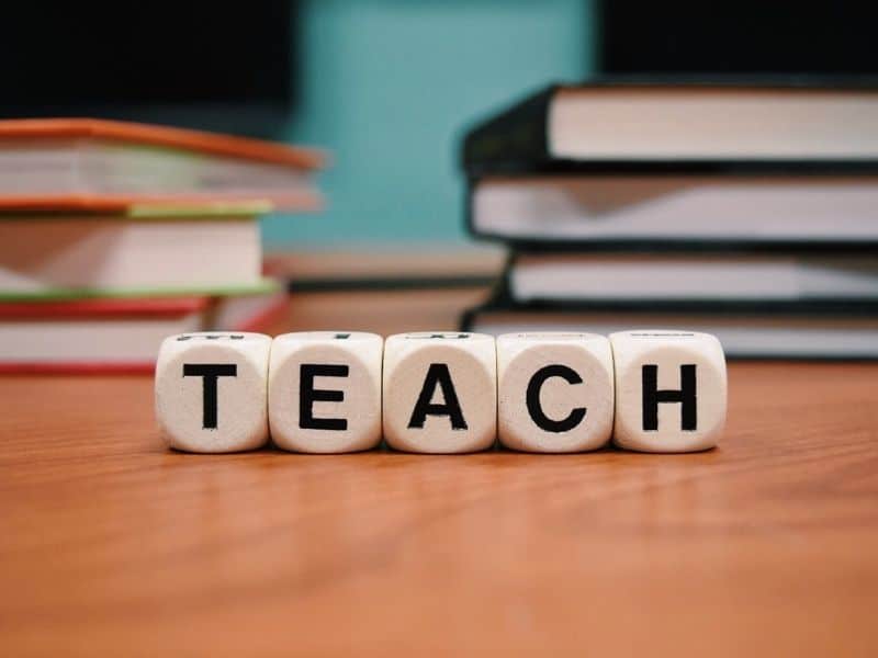 dice spelling "teach" on a table