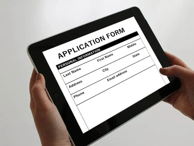 hands holding a tablet with application form on the screen