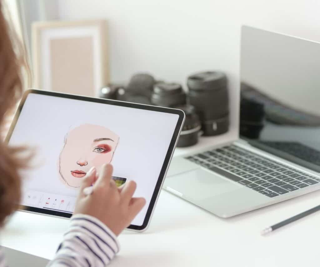 a woman creating a graphic design on her laptop