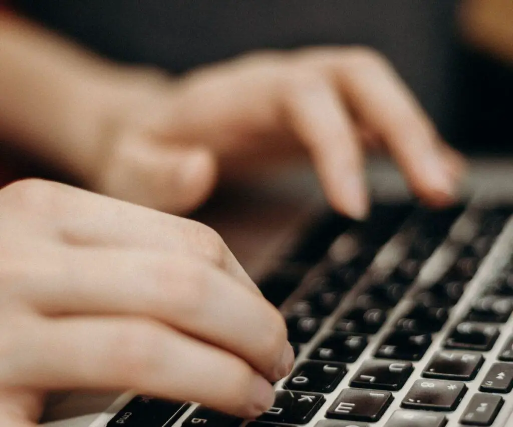 hands typing on a black keyboard