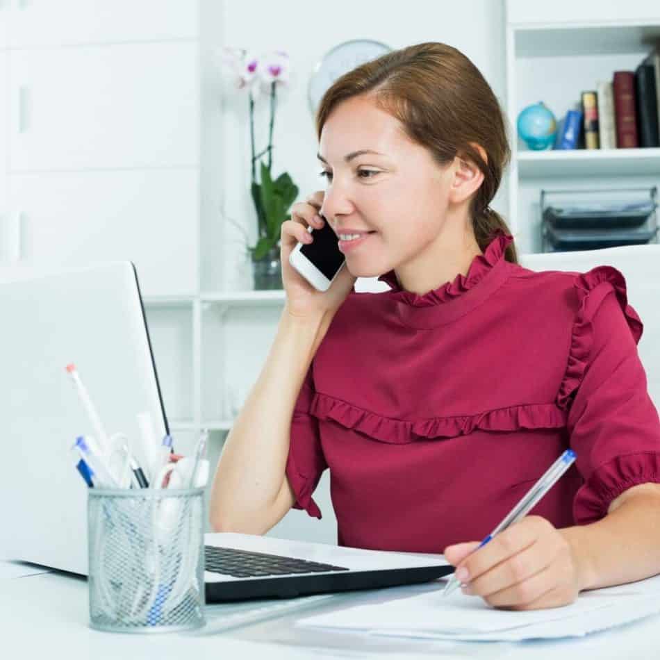 a woman talking on a cell phone at her desk