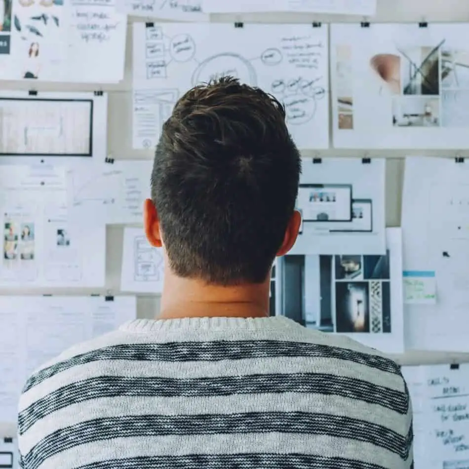 man looking at a bulletin board with his back turned