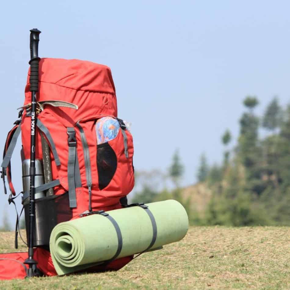 a red backpack with a yoga mat attached