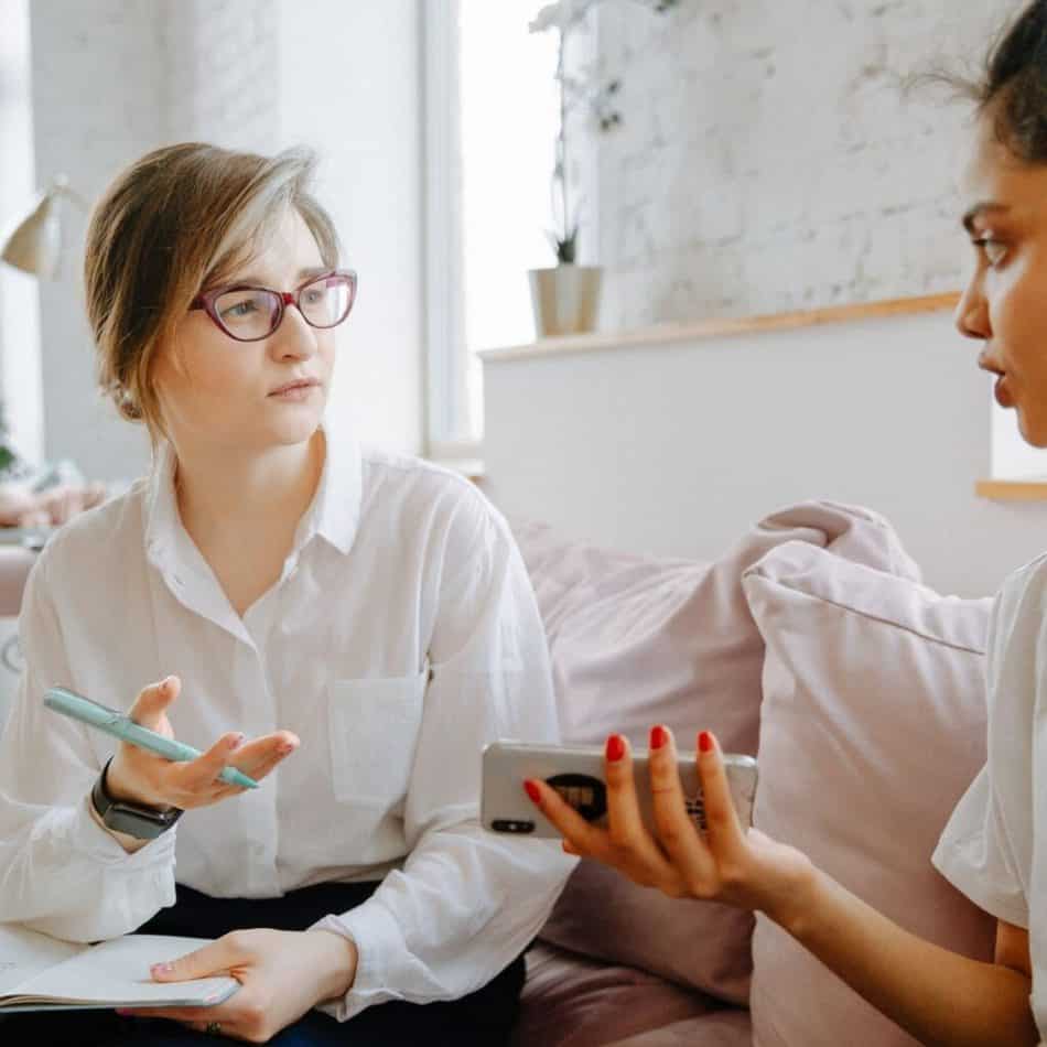 2 people haveing an informal meeting on a couch