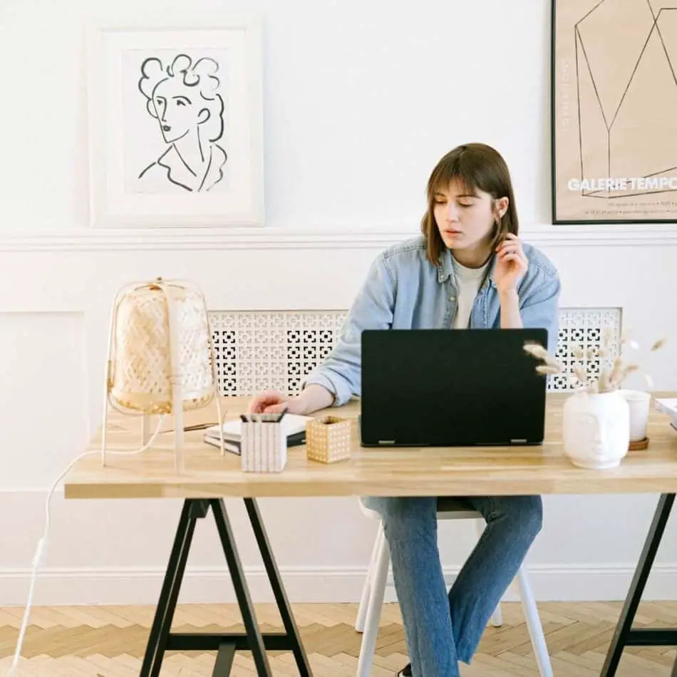 a woman sitting at a desk with a computer in front of her