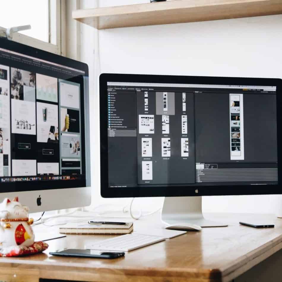 2 computer monitors sitting on a desk