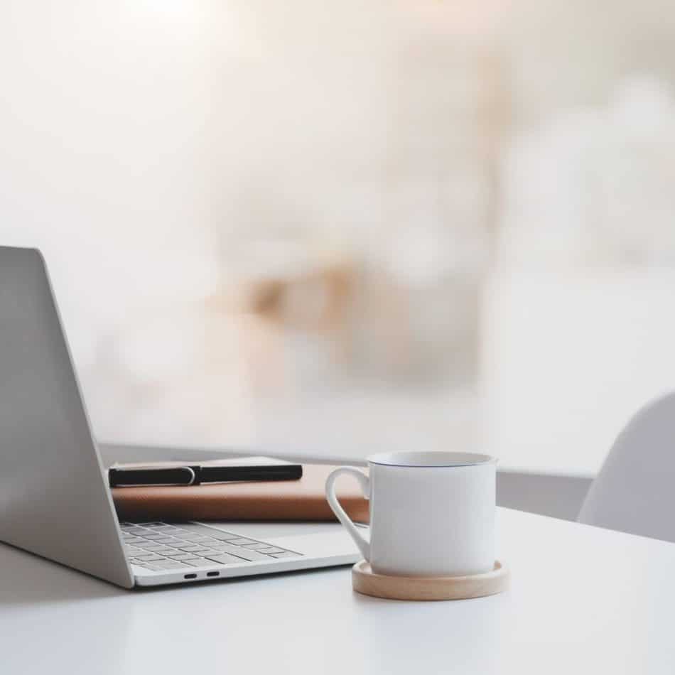 a mug on a desk next to a laptop